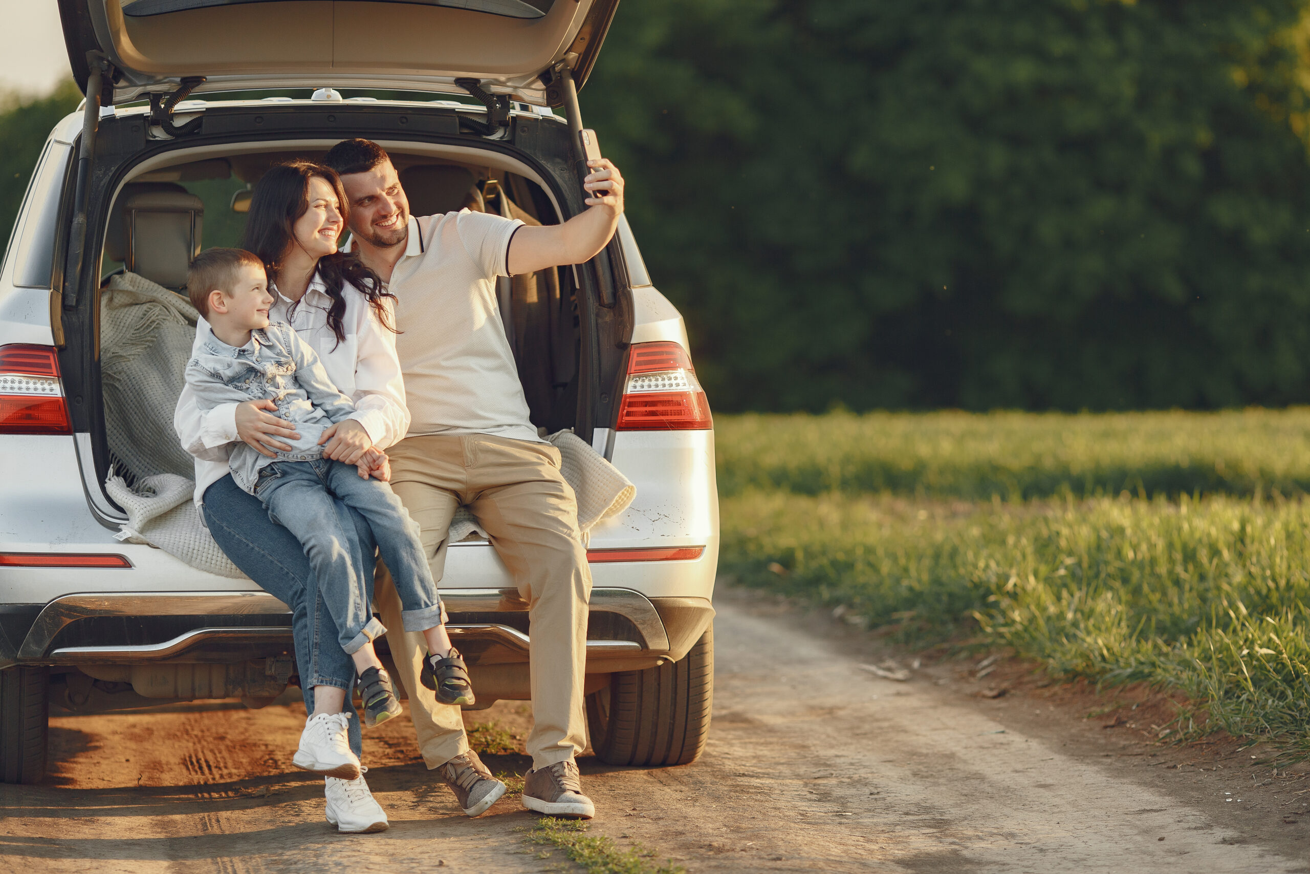 Family in a forest. People by the car. Sunset background.